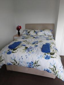 a bed with a blue and white comforter with blue flowers at Superb 2 bedroom flat, sleeps 6 in Croydon