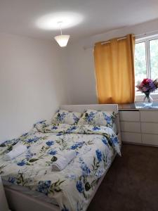 una camera da letto con un letto con fiori blu sopra di Superb 2 bedroom flat, sleeps 6 a Croydon