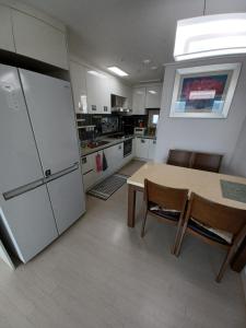 a kitchen with a table and chairs and a refrigerator at GOOD VIEW Guest House in Jeonju