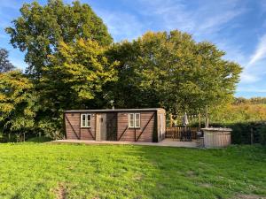 a small cabin in the middle of a grass field at The Hoppers' Halt in Staplehurst