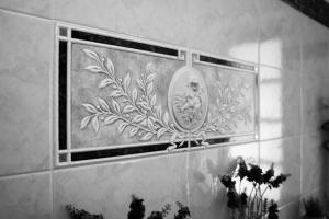 a mirror on a tiled wall with a picture at Agriturismo Rihane in Sinio