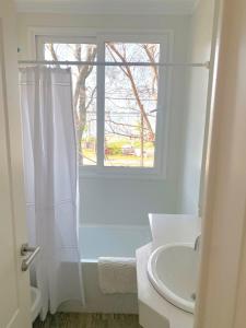 a white bathroom with a sink and a window at Espectacular departamento sobre la laguna para parejas in Chascomús +29 photos