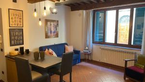 ein Esszimmer mit einem Tisch und einem blauen Sofa in der Unterkunft Maila Apartments 25min from Florence in Prato