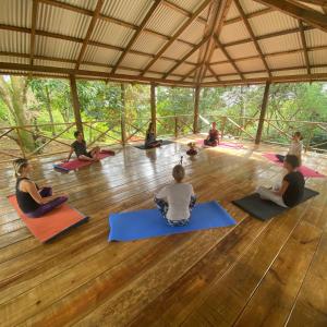 um grupo de pessoas sentadas no chão em uma aula de yoga em La Qhia Eco Retreat em Santa Fé