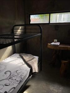 a small room with a bunk bed and a window at Duma Hostel in Dumaguete