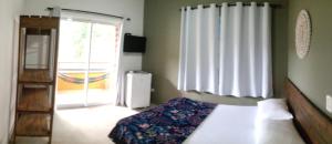 a bedroom with a bed and a sliding glass door at Camburi suites in Camburi