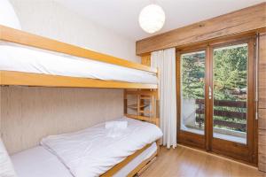 - une chambre avec 2 lits superposés et une fenêtre dans l'établissement Apartment La Foret, à Riddes