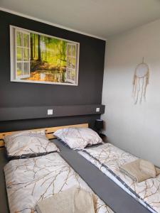 a bedroom with two beds and a painting on the wall at Apartment Harzfeuer mit wunderbarem Ausblick und Schwimmbad in Braunlage