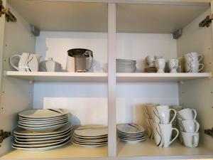 a cabinet filled with plates and cups and dishes at Apartment Harzfeuer mit wunderbarem Ausblick und Schwimmbad in Braunlage
