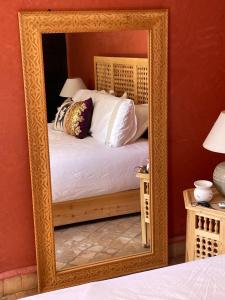 a large mirror in a bedroom with a bed at Riad Lalla Nora in Marrakech