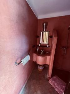 a pink bathroom with a sink and a mirror at Riad Lalla Nora in Marrakech