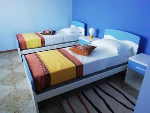 Latronico的住宿－Casa vacanze da Ricky e Nicky，蓝色墙壁客房的两张床