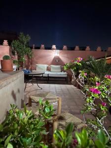 a patio with a couch and a table and some plants at Riad Lalla Nora in Marrakech