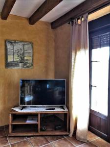 a living room with a flat screen tv and a window at La Nava de Gredos acogedor piso con vistas in Navarredonda de Gredos