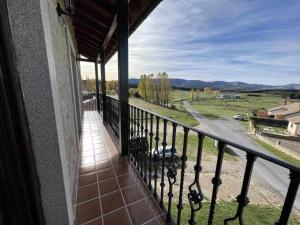 einen Balkon eines Hauses mit Blick auf eine Straße in der Unterkunft La Nava de Gredos acogedor piso con vistas in Navarredonda de Gredos
