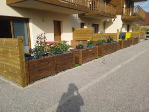 eine Reihe von Holzpflanzen an der Seite eines Gebäudes in der Unterkunft Les balcons la haie des grisselles in Gérardmer