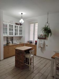 eine Küche mit weißen Schränken sowie einem Tisch und Stühlen in der Unterkunft Apartament przy Zamku in Pless