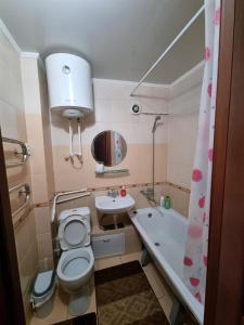 y baño con aseo, lavabo y bañera. en 1-комн центр, 45 квартал, Вокзал, Бухар-Жырау 69 en Karagandá