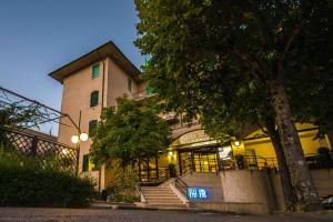 un edificio con una señal azul delante de él en Hotel Villa Ricci & Benessere en Chianciano Terme