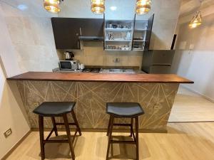 a kitchen with two bar stools and a counter at STUDIO BORJ RAYHANE in Tangier