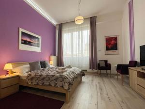 a bedroom with a bed and a purple wall at ABT Apartments Karoly in Budapest