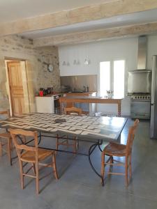 cocina con mesa y sillas en una habitación en Maison de charme avec bassin de nage 