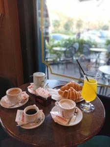 a table with cups of coffee and croissants on it at Amo's Hotel in Shkodër