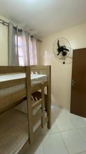 a room with a bunk bed with a fan on the wall at Hostel Mar in São Luís