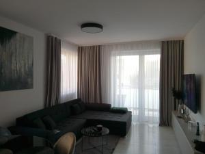 uma sala de estar com um sofá e uma grande janela em MBV28 Apartments em Poprad