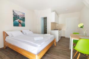 Mali Zvornik的住宿－MONTEKARLO NA DRINI，一间卧室配有一张床、一张桌子和绿色椅子