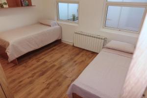 een kleine kamer met 2 bedden en 2 ramen bij Antolín Yellow Door in Ponferrada +11 foto's