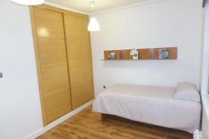 a small bedroom with a bed and a closet at Antolín Yellow Door in Ponferrada
