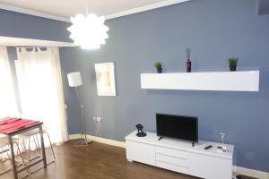 a living room with a tv on a blue wall at Antolín Yellow Door in Ponferrada