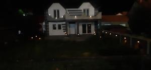 a white house with lights on it at night at Vila city in Bijeljina