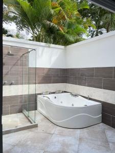 a bath tub in a bathroom with palm trees at Finca Hotel Casa Bela in Santa Fe de Antioquia