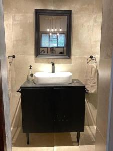 a bathroom with a sink and a mirror at Stacey's Cornerstone Studio Apartment in Hillcrest