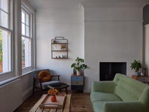 a living room with a green couch and a fireplace at *Unique Brighton Apartment & Garden, near Beach* in Brighton & Hove