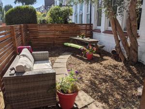 a backyard with a bench and a table and some plants at *Unique Brighton Apartment & Garden, near Beach* in Brighton & Hove