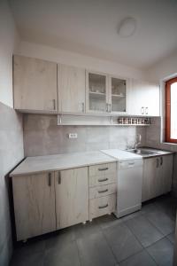 eine Küche mit weißen Schränken und einem Waschbecken in der Unterkunft Apartman Petunija in Sjenica