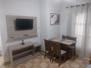 un salon avec une table à manger et une télévision dans l'établissement Apartamento a 50 mt da praia, tudo novo, à Praia Grande