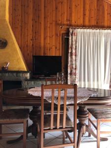 a dining room with a table and chairs and a television at Agradable casa con chimenea interior in Camprodon