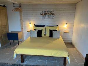 um quarto com uma cama grande com lençóis e almofadas amarelos em Maxilly appart em Saint-Paul-en-Chablais