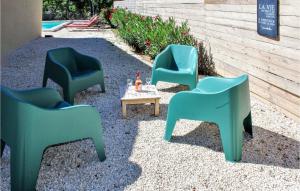 three green chairs and a table in a yard at La Comtesse in Grignan