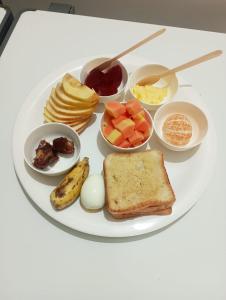 a plate of breakfast food with eggs fruit and toast at Assam Villa - by Storyweavers Retreat in Jorhāt