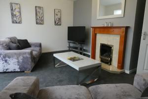 sala de estar con sofá y chimenea en Stylish 3 Bedroom House Near NEC, City Centre en Birmingham