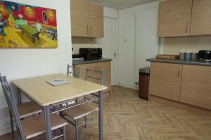 cocina con mesa y sillas en una habitación en Stylish 3 Bedroom House Near NEC, City Centre en Birmingham