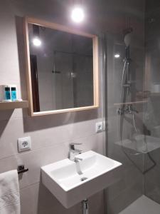 a bathroom with a sink and a shower at Hostal Quiper in Quiroga