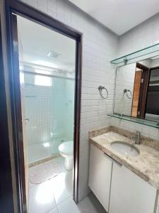een badkamer met een douche, een wastafel en een toilet bij Prédio beira mar - praia de Manaíra in João Pessoa