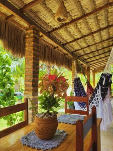a porch with a table with a potted plant at Vila Coqueiro - Moitas in Amontada +14 photos