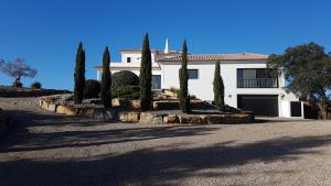 a white house with trees in front of a driveway at VILLA Casa Eden in Vila Nova De Cacela